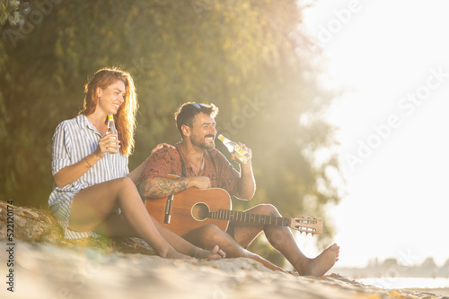 couple sitting on the beach with a guitar © Nemanja