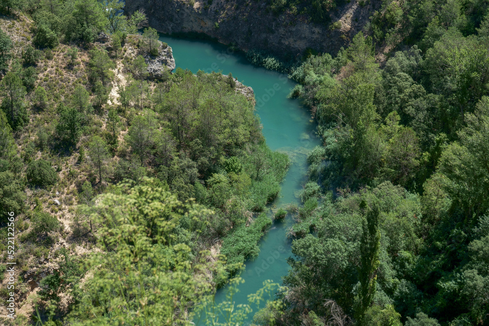 Views of a landscape in which the Júcar river appears with crystal clear water and turquoise green trees surrounding the river. Photograph taken from the Ventano del Diablo (Cuenca) Spain.