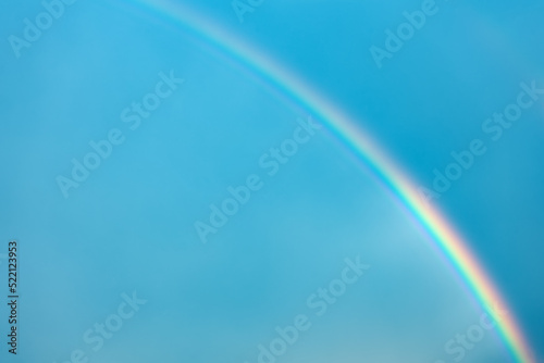 Multicolored rainbow on the background of the blue sky