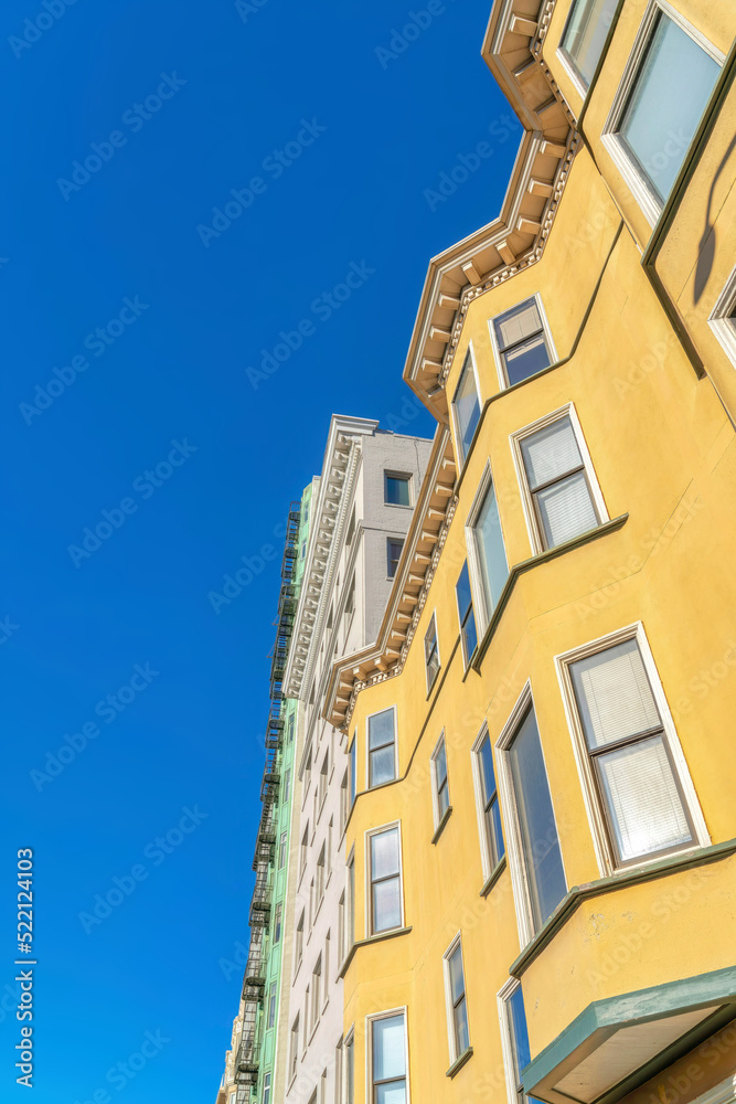 Low angle view of a residential building with yellow stucco wall in San Francisco, CA