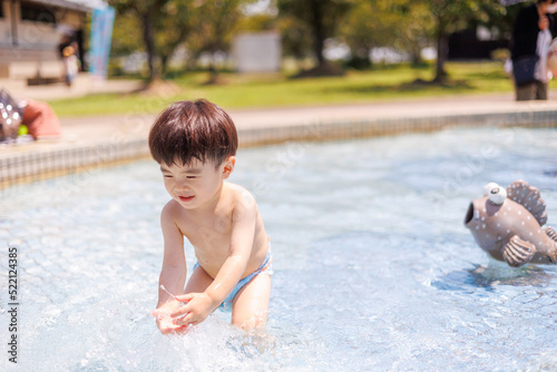 プールで水遊びをする男の子
