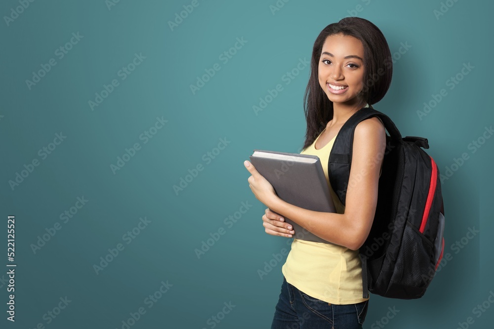 Happy young woman wearing a backpack while carrying books and notebooks go to college Happy young woman wearing a backpack while carrying books and notebooks go to college