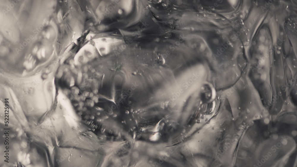 Ice cubes sparkling water spinning closeup in slow motion. Beverage concept Ice cubes sparkling water spinning closeup in slow motion. Beverage concept