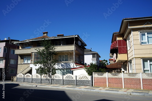 Villen und Wohnhäuser mit Zaun und Mauer vor blauem Himmel im Sommer bei Sonnenschein in Adapazari in der Provinz Sakarya in der Türkei photo