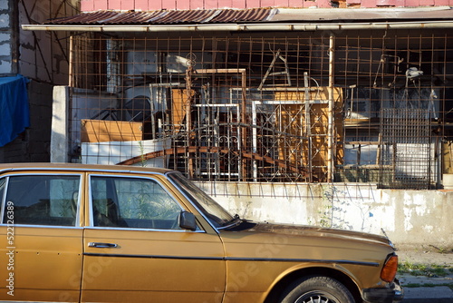 Heruntergekommene deutsche Mittelklasse Limousine der Siebzigerjahre und Achtzigerjahre als Gebrauchtwagen bei Sonnenschein vor einer Werkstatt in Adapazari in der Provinz Sakarya in der Türkei  photo