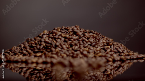 Closeup coffee beans heap super slow motion. Roasted caffeine grains background