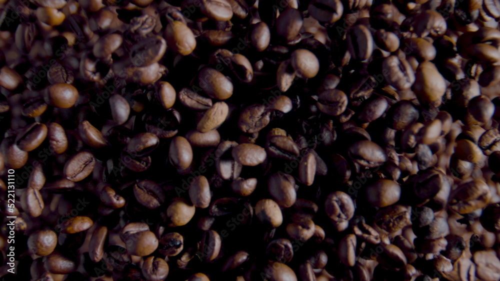 Fototapeta premium Process grinding coffee grains close up. Top view rotating fresh aromatic beans