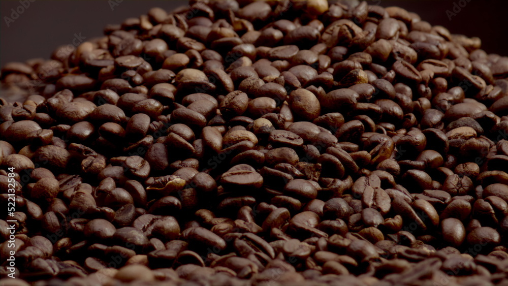 Obraz premium Textured coffee grains background closeup. Light steam coming from roasted seeds