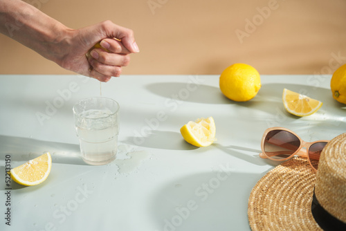 Squeezing lemon into glass of water photo