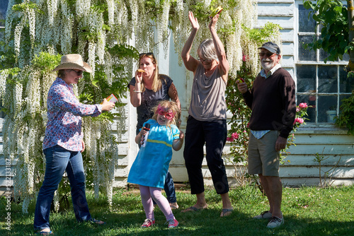 Little girl and family having fun times in the garden