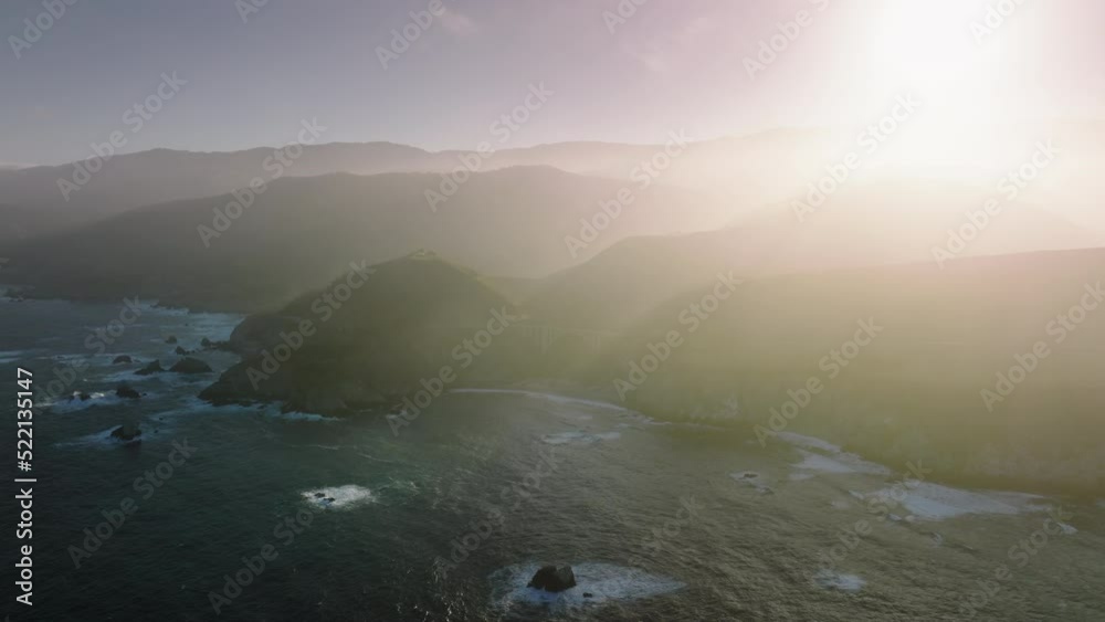 Highway 1 through the coastline by the Pacific Ocean. Aerial view of California Scenic Byway with sunset skyline in the background. High quality 4k footage Highway 1 through the coastline by the Pacific Ocean. Aerial view of California Scenic Byway with sunset skyline in the background. High quality 4k footage