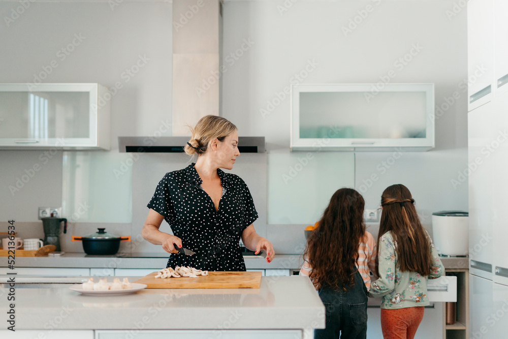 Mother and daughters at kitchen Mother and daughters at kitchen