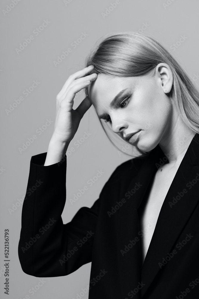 Fashion model girl posing with her hands up in the studio in black and white style in a classic jacket Fashion model girl posing with her hands up in the studio in black and white style in a classic jacket