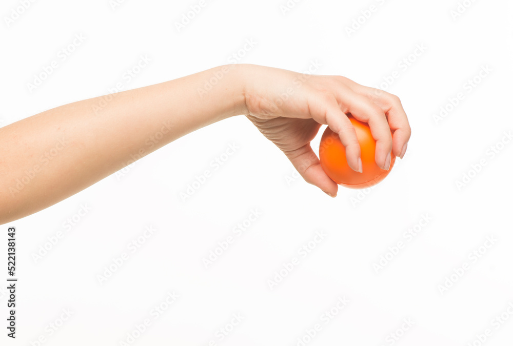 female hands holding an orange sponge ball on a white background isolated female hands holding an orange sponge ball on a white background isolated