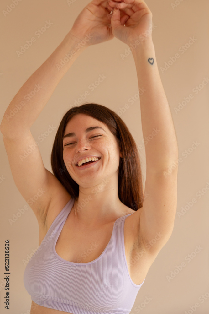 a funny woman studio portrait with her arms up while is laughing a funny woman studio portrait with her arms up while is laughing