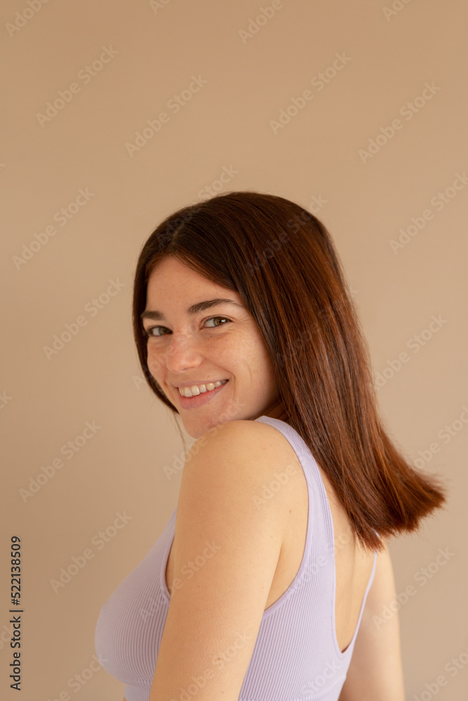 A beatiful woman similing at camera over brown background A beatiful woman similing at camera over brown background