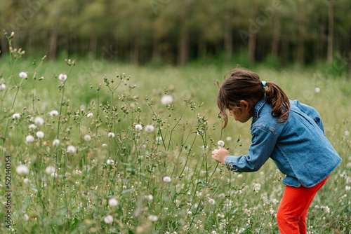Girl blowing at white flower