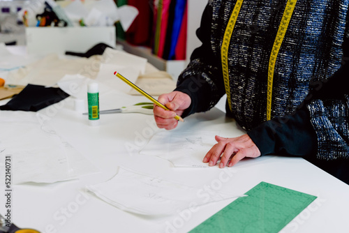 Obraz na płótnie woman designing the clothes she creates in her workshop with pencil and paper. w salonie