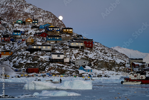 Indigenous Inuit town, Greenland Arctic: 
harbour in winter, full moon photo
