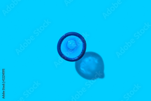Single condom on blue background.