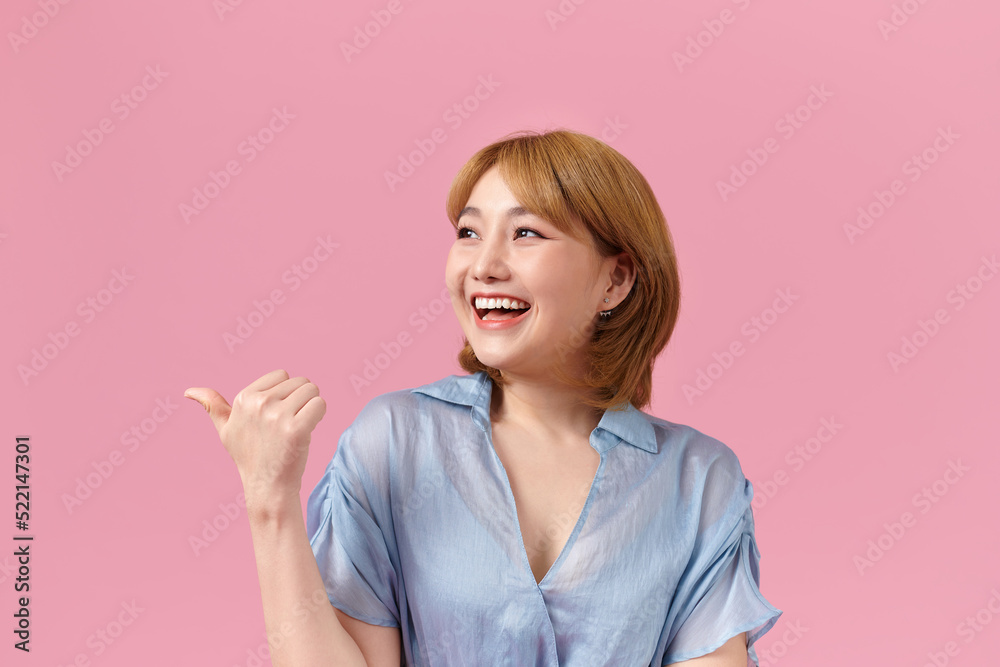 Smiling young woman isolated on pink background point with finger Smiling young woman isolated on pink background point with finger