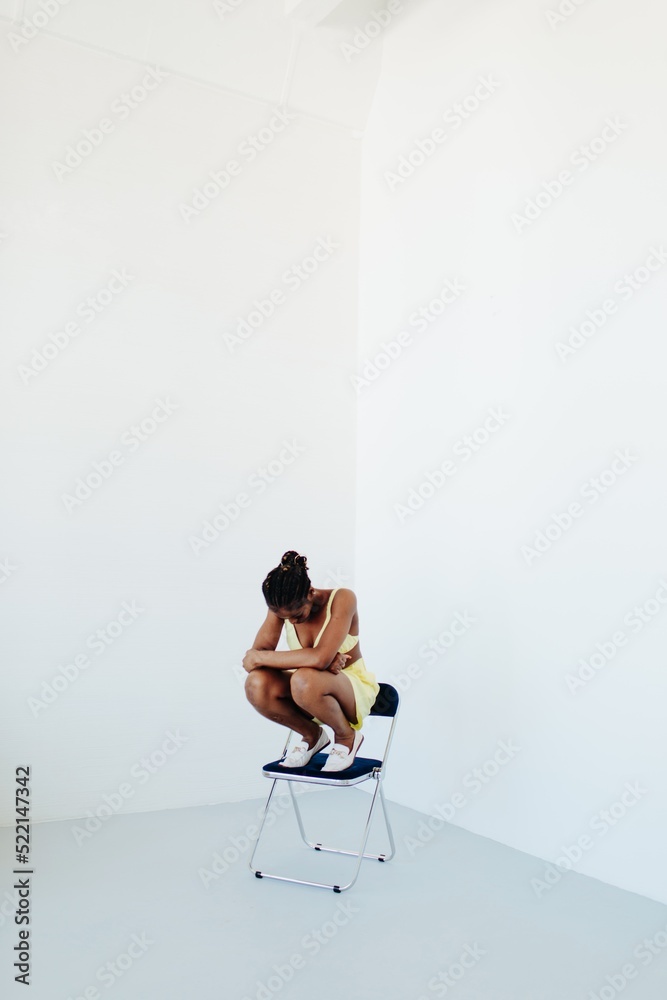 Black woman sit on chair - depression - Minimal fashion Black woman sit on chair - depression - Minimal fashion
