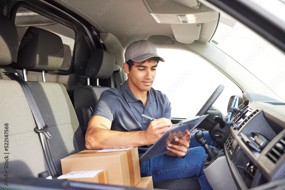 Delivery man making notes in van Delivery man making notes in van