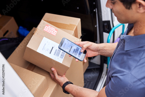 Cropped delivery man scanning barcode on parcel