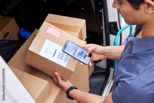 Cropped delivery man scanning barcode on parcel photo