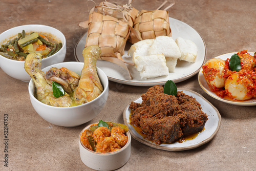 Ketupat Lebaran, served with sambal goreng, opor ayam, sayur labu siam, rendang and telur balado. Traditional celebratory menu during Eid al-Fitr and Eid al-Adha in Indonesia photo