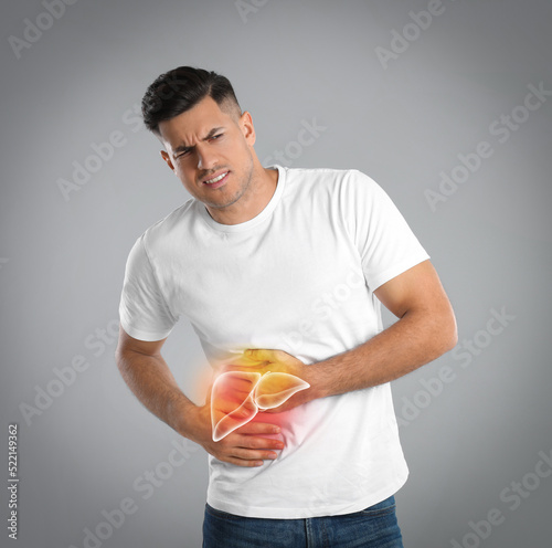 Foto Man suffering from liver pain on grey background