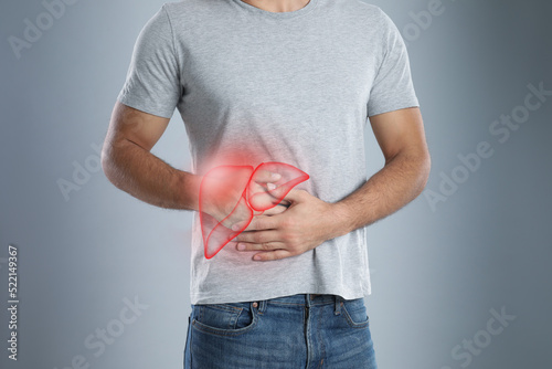 Man suffering from liver pain on grey background, closeup