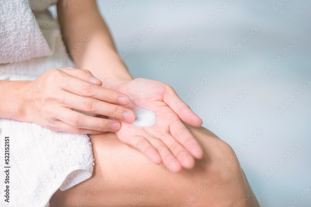 Asia woman applying moisturizing cream/lotion on hands, beauty concept.