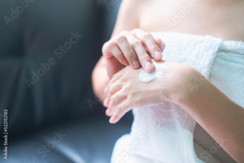 Asia woman applying moisturizing cream/lotion on hands, beauty concept.