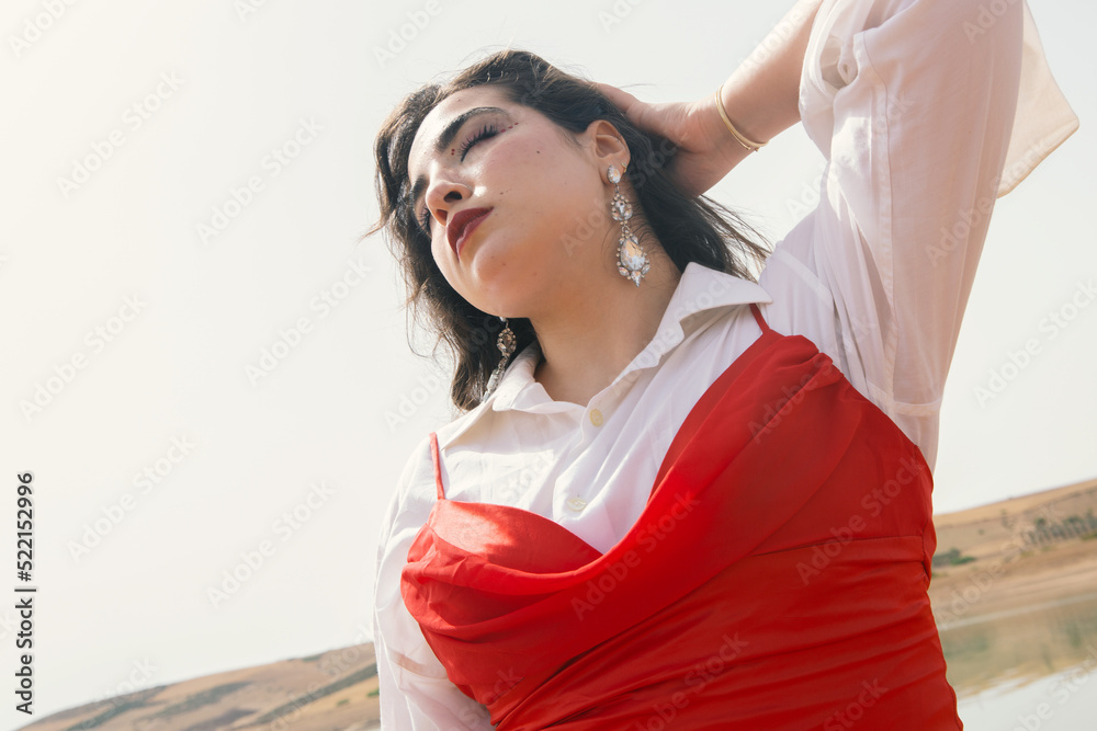 Beautiful young girl with long black hair wearing red dress in nature ...