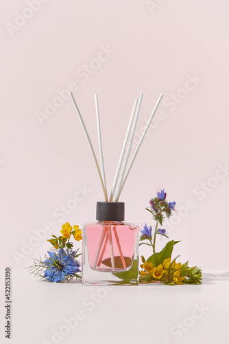 Aroma diffuser with rattan sticks and garden flowers.