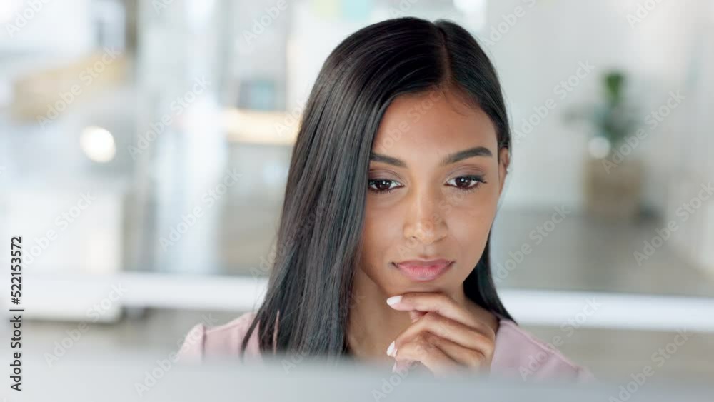 Thinking businesswoman working on a computer desktop analyzing social media analytics or data report with a modern bright background. Young marketing intern doing online website research