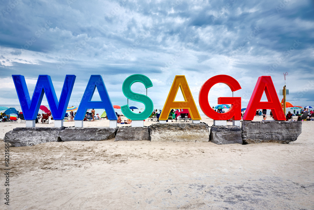 Colourful giant Wasaga beach sign sitting on big rocks at Ontario