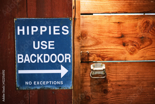 A sign saying Hippies use the back door photo