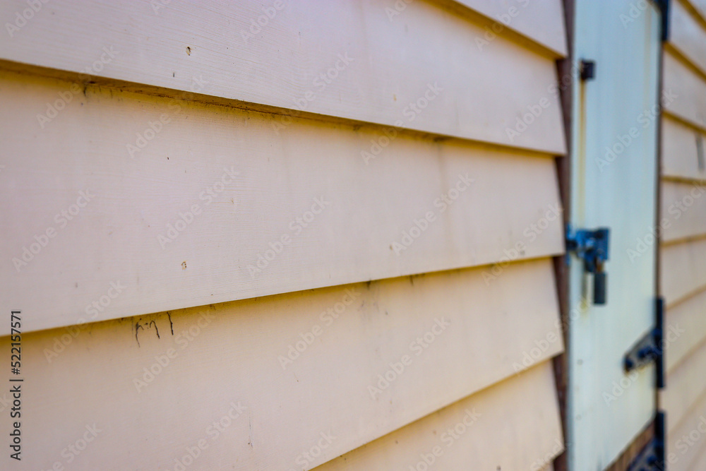 old weatherboard wall and bolted door in selective focus old weatherboard wall and bolted door in selective focus