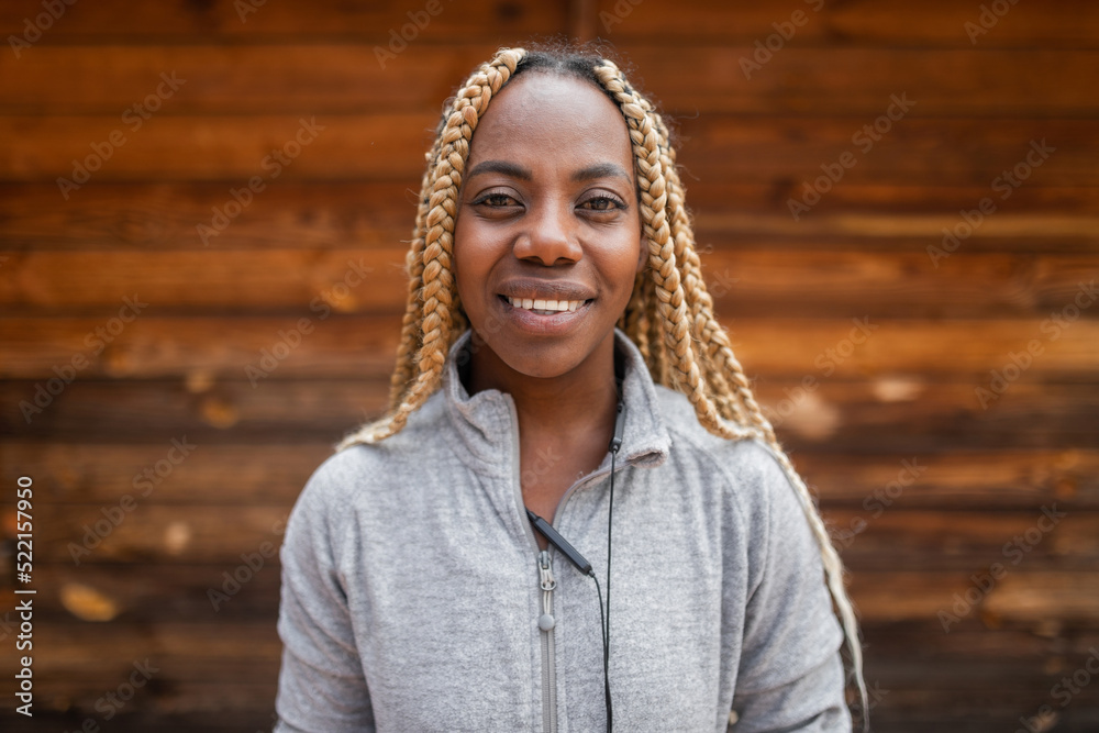 © Lupe Rodríguez/Stocksy - portrait of young black woman with blonde braids and sportswear