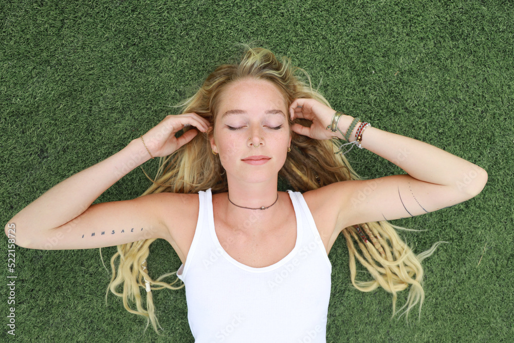 © Rene de Haan/Stocksy - young woman relaxing on grass