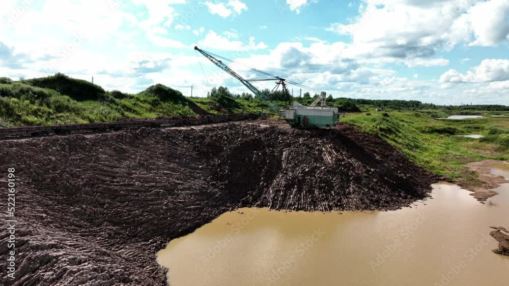 Open-pit mining. Dragline excavator load clay in freight train. Clay ...