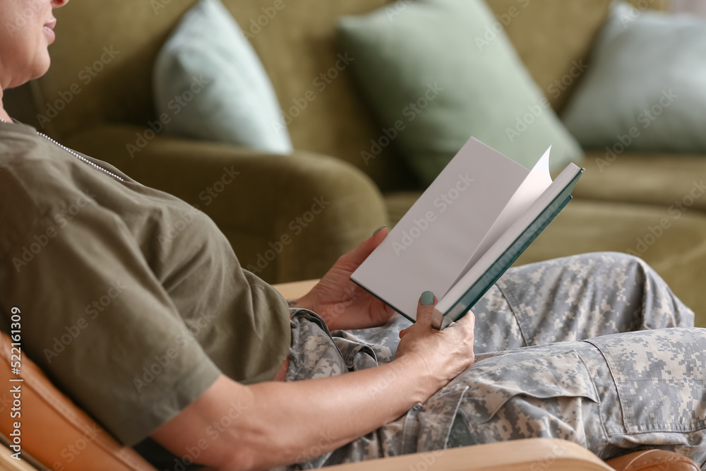 Mature female soldier reading book at home, closeup Mature female soldier reading book at home, closeup