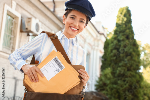 Young postwoman taking lett...