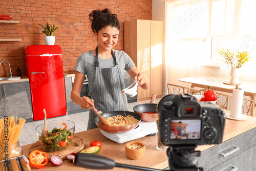 Young woman pouring pasta w...