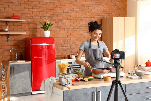 Young woman cooking pasta w...