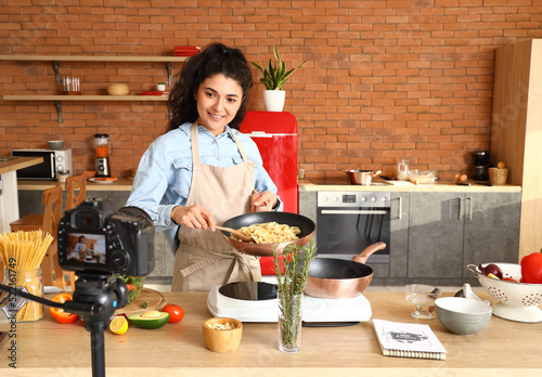 Young woman cooking pasta w...
