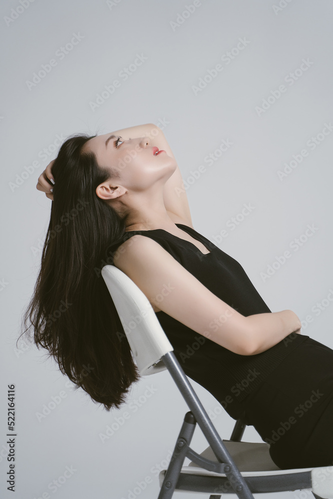 © ZQZ Studio/Stocksy - Portrait of young woman sitting on a chair © ZQZ Studio/Stocksy - Portrait of young woman sitting on a chair
