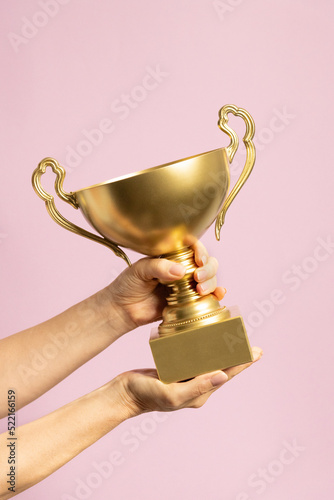 Winner holding golden cup. Success and achievement, victory concept.